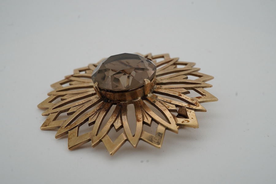A smoky quartz brooch, set with a circular-cut smoky quartz, within a floral gold surround, 5.7cm diameter, stamped 9CT, maker's mark JF, stamped IVSS, gross weight 17 grams